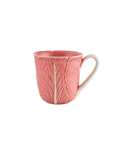 Pink ceramic mug with leaf pattern on a white background
