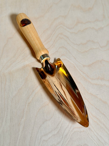 Bronze trowel on a birch ply background