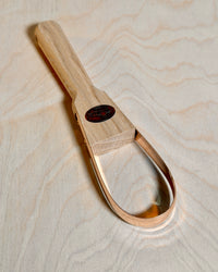 Bronze weeding tool on birch ply background