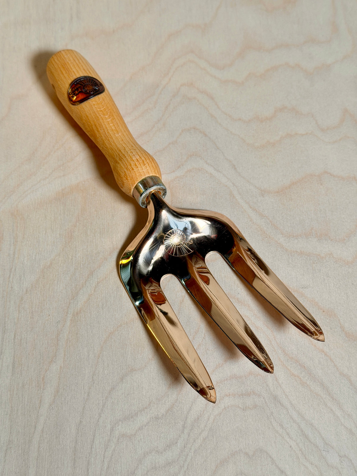 Bronze fork on a birch ply background