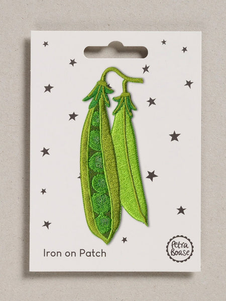 Green pea pod iron-on patch on a white card with star patterns